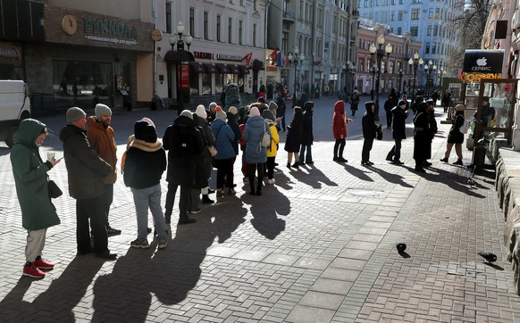 epa09812765 People wait in line to withdraw cash from a ATM of Tinkoff Bank downtown Moscow, Russia 09 March 2022. Russian troops entered Ukraine on 24 February 2022, prompting a series of severe econ ...