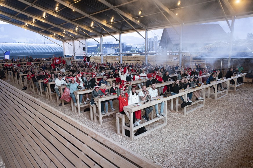 Swiss soccer fans react during the live broadcast of the UEFA EURO 2020 soccer match between France and Switzerland at the public viewing zone Wood Ball Arena in Bulle, Switzerland, Monday, 28 June 20 ...