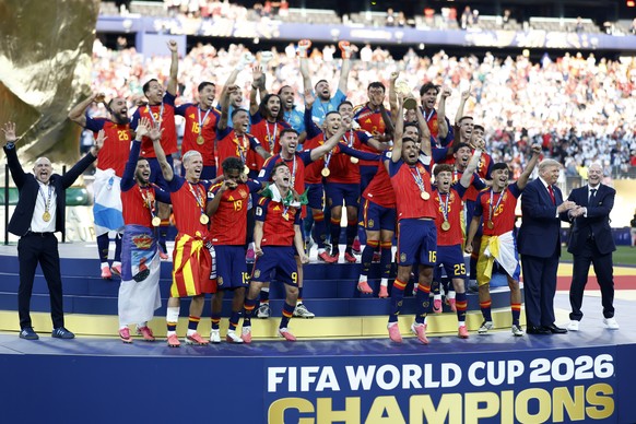 epa13122027 Rodri (C-R) and players of Spain celebrate with the World Cup Trophy as FIFA President Gianni Infantino (R) interacts with US President Donald J. Trump during the awards ceremony after the ...