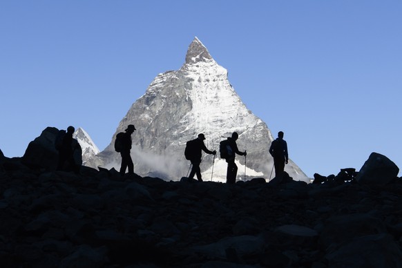 epa09473564 Festival-goers come down after a concert of the French Band Tournee des Refuges the day before at the Monte Rosa Hut (2,883m), with a view of Cervin (Matterhorn) Mountain, during the Zerma ...