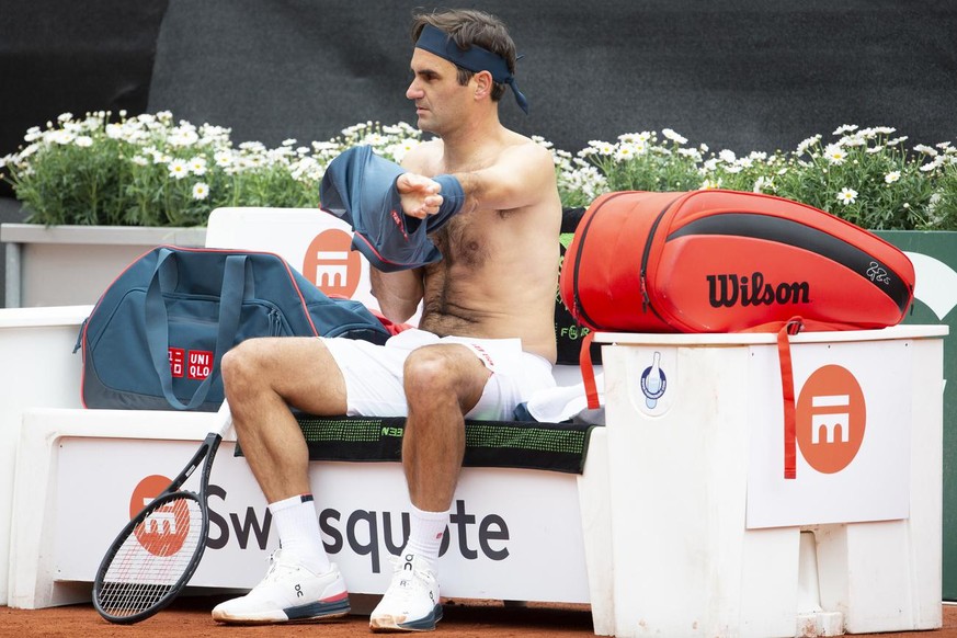 Roger Federer of Switzerland changes his shirt during a break during the men&#039;s second round match against Pablo Andujar of Spain, at the ATP 250 Geneva Open tournament in Geneva, Switzerland, Tue ...