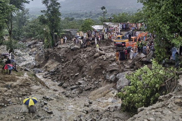 Rescuers and local residents use heavy machinery to recover bodies during a rescue operation at the site of a massive cloudburst that led to flash flooding, in Salarzai, in Bajaur district, in northwe ...