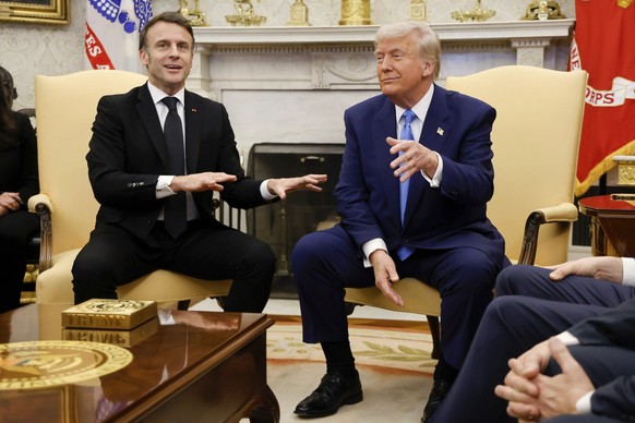 France's President Emmanuel Macron speaks as President Donald Trump listens during a meeting in the Oval Office of the White House in Washington, Monday, Feb. 24, 2025. (Ludovic Marin/Pool via AP ...