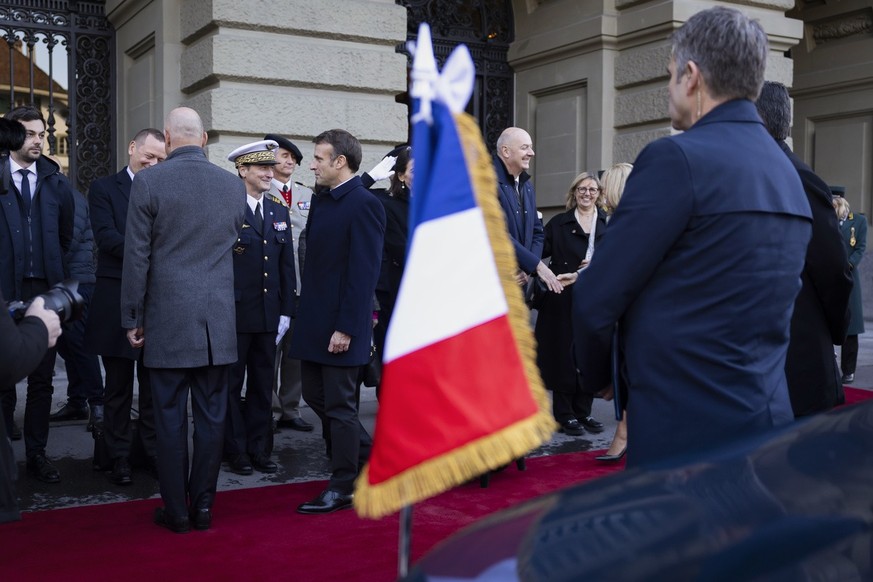 Swiss Federal President Alain Berset, left, welcomes the delegation members of French President Emmanuel Macron in front of the Federal Palace, the Swiss Parliament building, in Bern, Switzerland, on ...