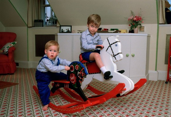 LONDON, UNITED KINGDOM - OCTOBER 22: Prince William And Prince Harry Playing On A Rocking Horse In Their Playroom At Kensington Palace (Photo by Tim Graham Photo Library via Getty Images)