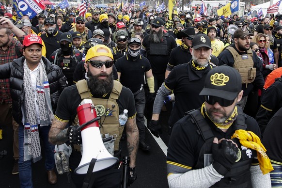 Far-right Proud Boys member Jeremy Joseph Bertino, second from left, joins other supporters of President Donald Trump who are wearing attire associated with the Proud Boys as they attend a rally at Fr ...
