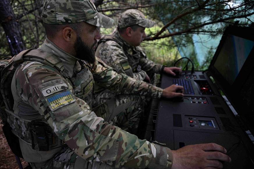 Des militaires du Service national des gardes-frontières ukrainiens pilotent un drone lors d'un vol de patrouille le long de la frontière entre l'Ukraine et la Biélorussie.