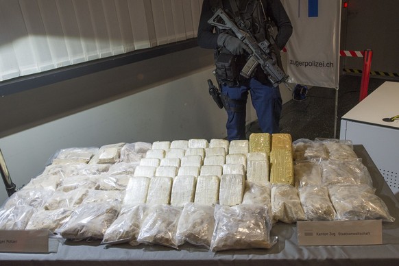 Ein Polizist bewacht die beschlagnamten 55 Kilogramm Heroin waehrend eine Polizeipraesentation, am Dienstag, 25. November 2014, in Zug. Die Zuger Strafverfolgungsbehoerden zerschlagen, nach einem Tip  ...