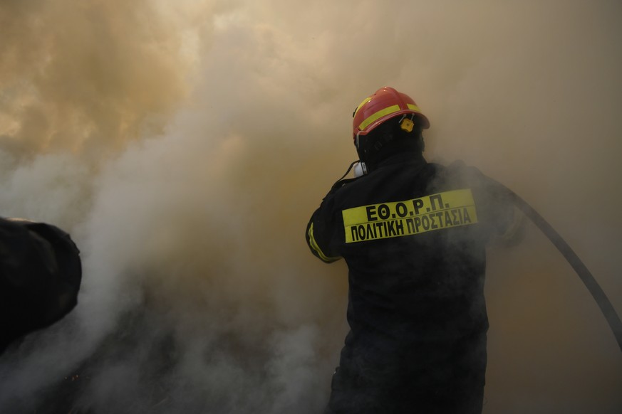 A firefighter operates in Dioni, northeast of Athens, Greece, Monday, Aug. 12, 2024. Hundreds of firefighters backed by dozens of water-dropping planes and helicopters were battling the flames from fi ...