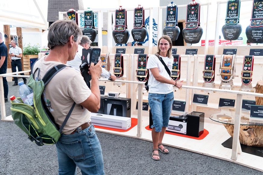 Eine Frau laesst sich vor den Glockenpreisen fotografieren im Gabentempel auf dem Festgelaende, am Freitag, 12. August 2022, in Pratteln. Vom 26. bis 28. August findet hier das Eidgenoessische Schwing ...