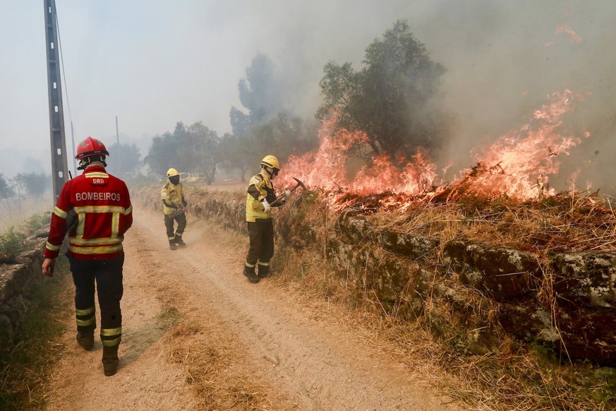 epa12273276 Firefighters battle a fire in the village of Santa Comba, Seia, Portugal, 30 July 2025. The fire, which broke out in the municipality of Seia, Guarda district, is being fought by 180 opera ...