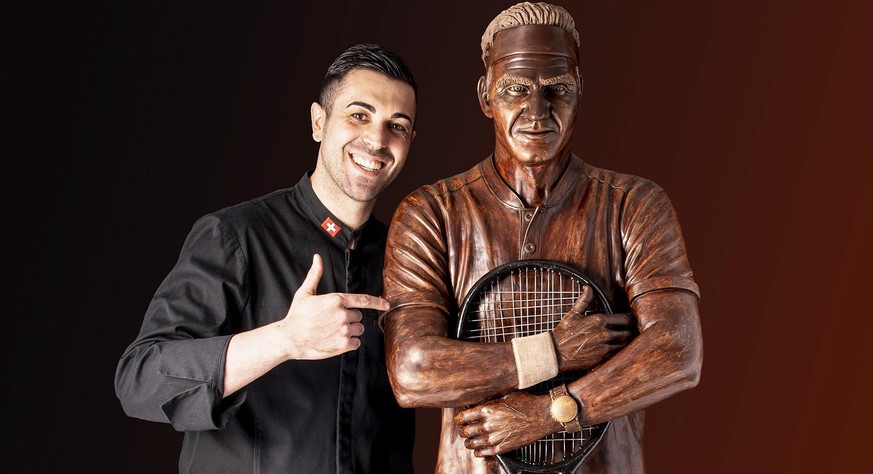 Jorge Cardoso pose à côté de sa statue de Federer en chocolat.