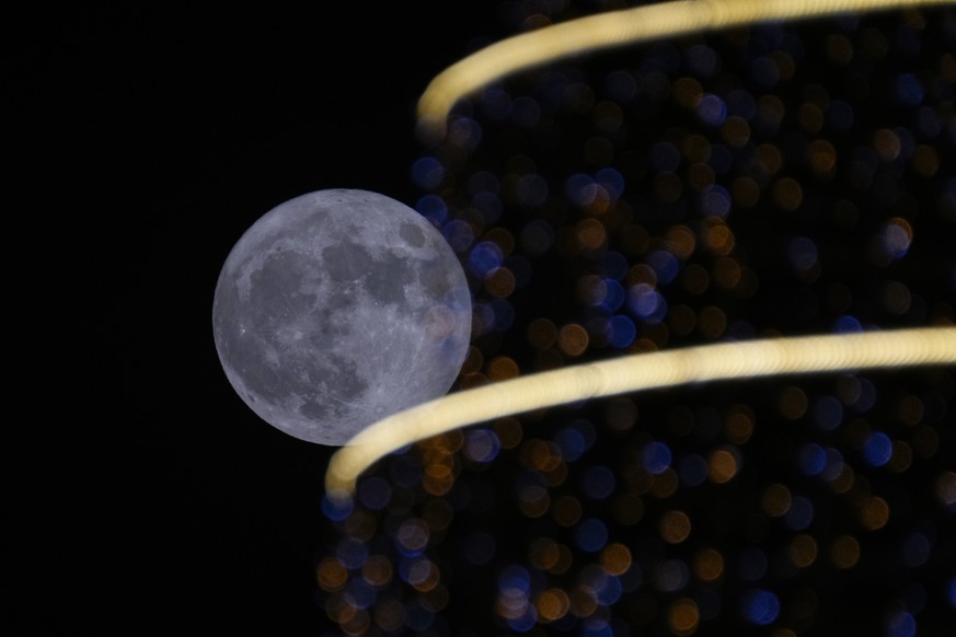 The full moon rises over Baghdad, Iraq, on Wednesday, July 13, 2022. The Full Moon is known as the Buck Moon and also a Supermoon. (AP Photo/Hadi Mizban)