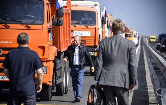 epa06738688 Russian President Vladimir Putin (C) walks after driving the first truck during the opening ceremony of the road-and-rail Krymsky (Crimean) Bridge over the Kerch Strait, Crimea, 15 May 201 ...