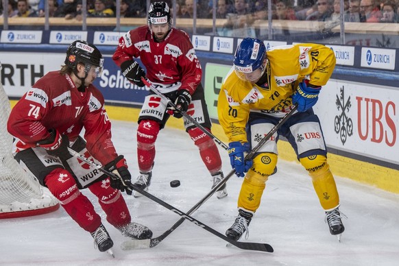 Nicola Beaudin, left, from Canada play against Enzo Corvi, right, from Davos during the game between Team Canada and Switzerland&#039;s HC Davos at the 95th Spengler Cup ice hockey tournament in Davos ...