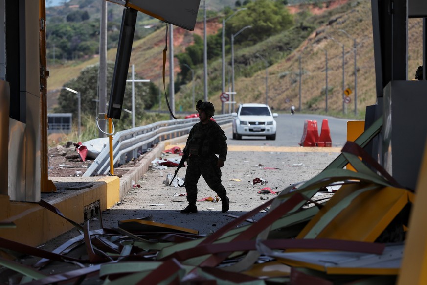 A soldiers walks through a toll plaza along the Pan-American Highway damaged in a explosion that the army blamed on FARC dissident groups in Santander de Quilichao, Colombia, Saturday, Aug. 8, 2026. ( ...