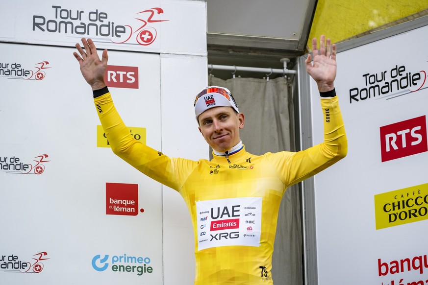 The winner of the stage and overall leader Tadej Pogacar from Slovenia of UAE Team Emirates XRG celebrates on the podium with the yellow jersey during the first stage, a 170,6 km race around Martigny  ...