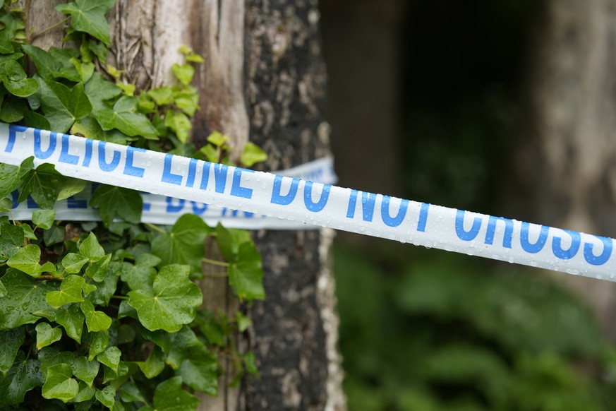 A police security tape is seen in Grenfell Park, in Maidenhead, England, Wednesday May 22, 2024, close to where the body of Matthew Trickett was found on Sunday. Trickett, one of three men charged ear ...