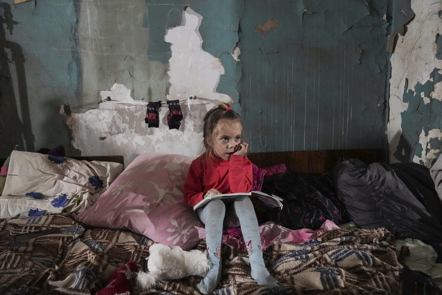 A girl sits in an improvised bomb shelter in Mariupol, Ukraine, Monday, March 7, 2022. (AP Photo/Evgeniy Maloletka)
