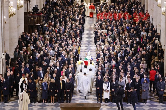 epa11763407 Paris&#039; Archbishop Laurent Ulrich (C) leads clergy members as they walk down the central aisle of the Notre-Dame Cathedral during a ceremony to mark its reopening, in Paris, France, 07 ...