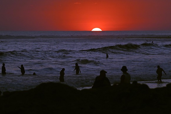 Tourists enjoy sunset at El Tunco beach, in La Libertad, El Salvador, on February 13, 2026. Amid picture-perfect waves and sunsets, foreign tourists enjoy the Salvadoran beach of El Tunco, once plague ...