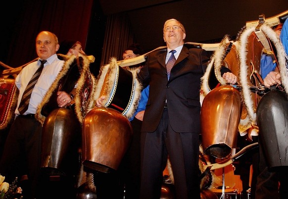 Bundesrat Christoph Blocher, rechts, macht zusammen mit SVP-Praesident Ueli Maurer, links, und einer Treichelgruppe Stimmung im Albisgueetli, am Freitag, 14. Januar 2005, an der 17. Albisgueetli-Tagun ...