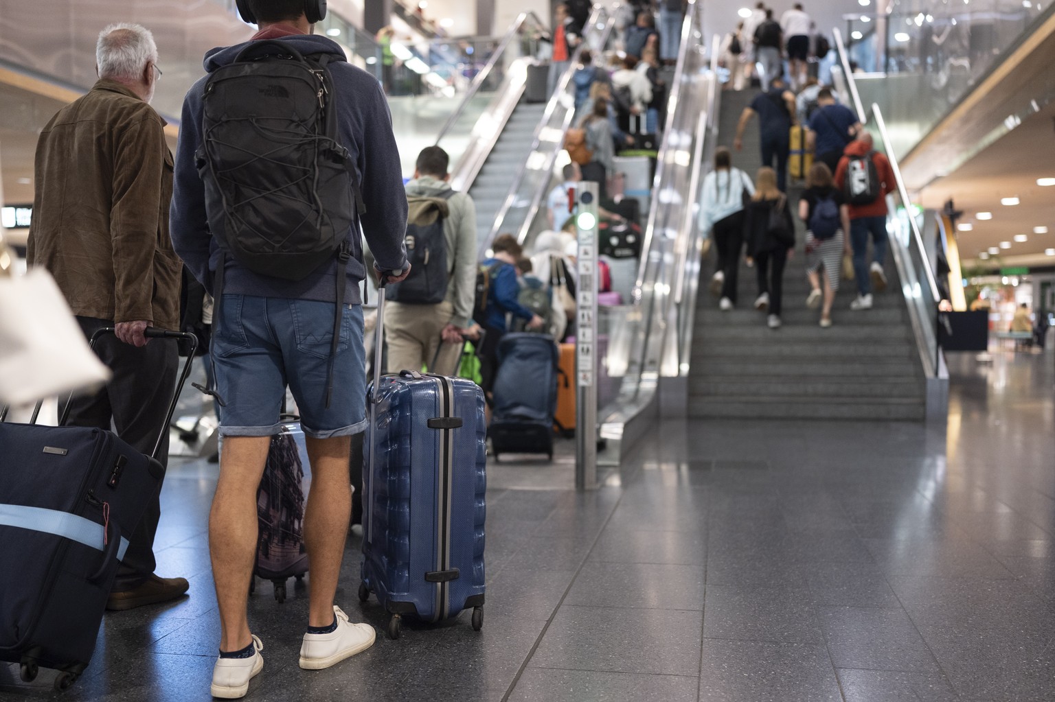 Passagiere gehen mit Koffer, Taschen oder Rucksaecken zum Ferienbeginn durch die Hallen zu den Check-In-Schaltern, aufgenommen am Samstag, 13. Juli 2024 auf dem Flughafen in Kloten. (KEYSTONE/Ennio Le ...
