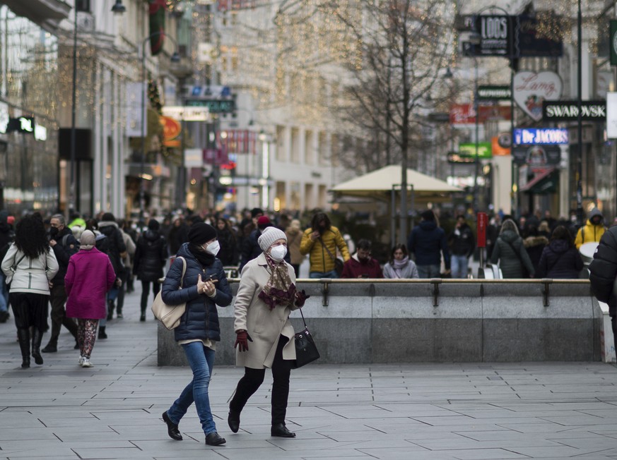 People wearing face mask to protect against the coronavirus as they walk at a shopping street in Vienna, Austria, Wednesday, Nov. 17, 2021. The Austrian a nationwide lockdown for unvaccinated people i ...