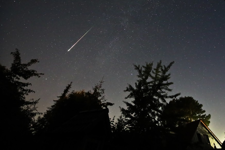13.08.2023, Schleswig-Holstein, Neum�nster: Ein Perseidenmeteor zieht �ber den Himmel gegen 04:00 Uhr MESZ in Neum�nster (Stadtteil Tungendorf). Ab 23 Uhr hatte sich der Himmel �ber weiten Teilen Schl ...