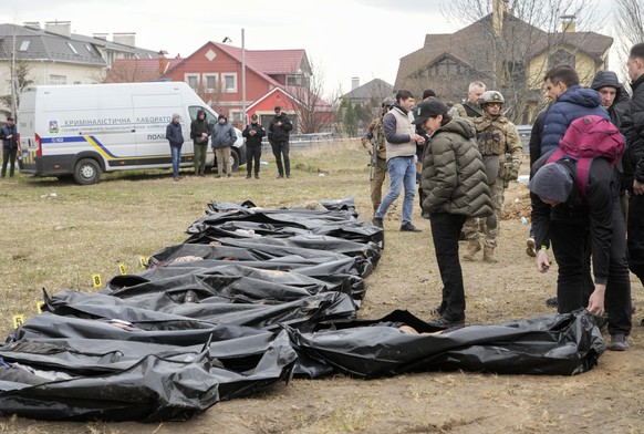 FILE - Ukrainian Prosecutor General Iryna Venediktova, center, looks at the exhumed bodies of civilians killed during the Russian occupation in Bucha, on the outskirts of Kyiv, Ukraine, Friday, April  ...