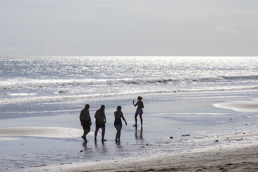 epa12864032 Tourists spend time at a beach in Canggu, Bali, Indonesia, 01 April 2026. The Indonesia Central Agency of Statistics recorded nearly 1.16 million foreign tourist arrivals in February 2026, ...