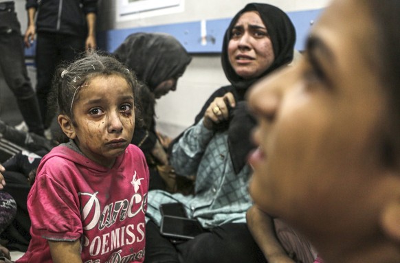 Wounded Palestinians sit in al-Shifa hospital in Gaza City, central Gaza Strip, after arriving from al-Ahli hospital following an explosion there, Tuesday, Oct. 17, 2023. The Hamas-run Health Ministry ...