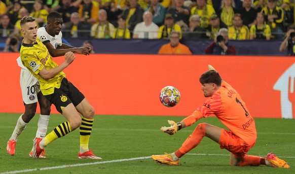 epa11313403 PSG&#039;s Ousmane Dembele (L) in action against Borussia&#039;s goalkeeper Gregor Kobel (R) and Nico Schlotterbeck (2-L), during the UEFA Champions League semi final, 1st leg match betwee ...