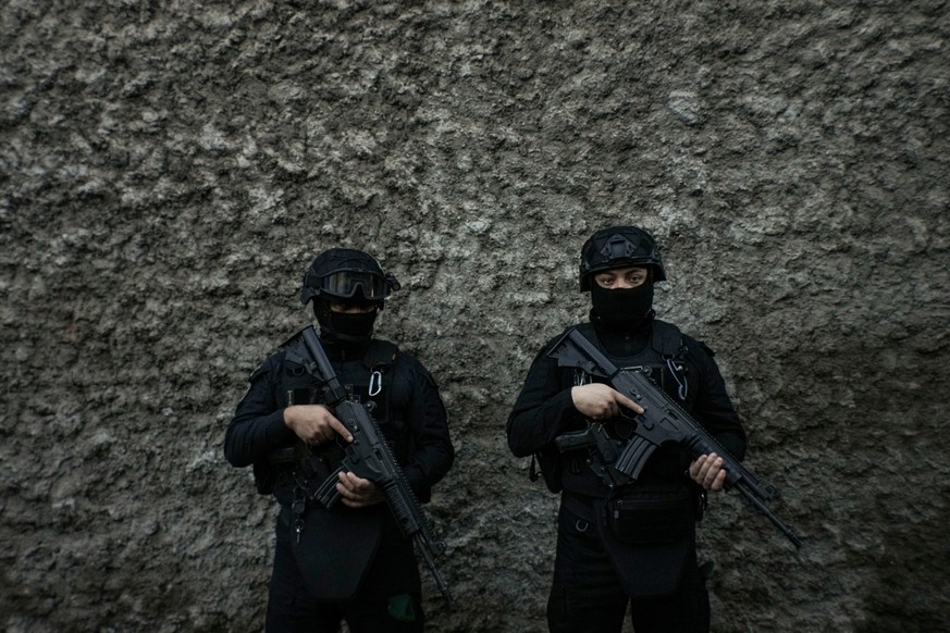 Police stand guard before a press conference on the extradition of Tren de Aragua gang members from the United States, at the a high-security prison where they are being held in Santiago, Chile, Wed ...