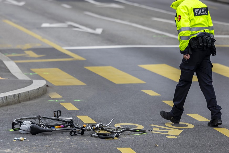 Un policier de la police genevoise regarde le velo du cycliste, qui a perdu la vie apres avoir ete renverse par un camion a l'angle de l'avenue Guiseppe Motta et le chemin Camille Vidart, ce ...
