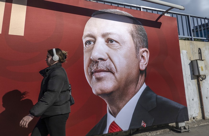 epa10413230 A woman walks in front of a picture of the Turkish President Recep Tayyip Erdogan in Istanbul, Turkey, 18 January 2023. President Erdogan announced that the presidential election could be  ...