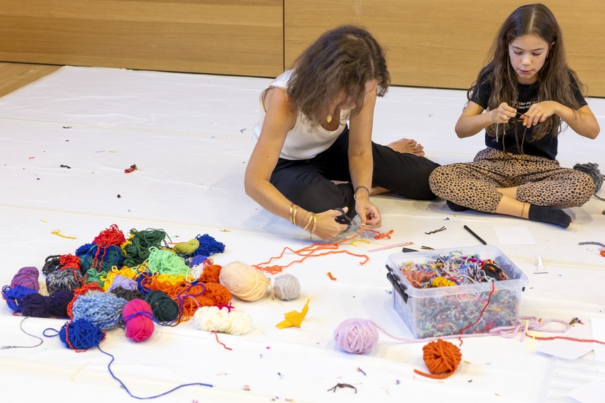 Une visiteuse avec sa fille preparent de la laine pour faire des portraits dans l&#039;atelier &quot;Mouton? Eh bien laine!&quot;, lors de la journee &quot;Enfin dimanche!&quot; La Comedie de Geneve o ...