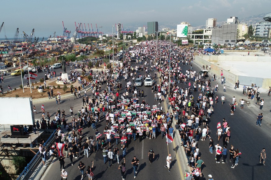 epa09395579 A picture taken with a drone shows Lebanese protesters gather outside the Beirut port to commemorate the first year anniversary of the Beirut port, in Beirut, Lebanon, 04 August 2021. Leba ...