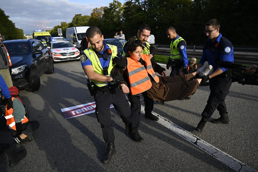 epa10222223 An environmental activists from Renovate Switzerland is detained during a sit-in protest against climate change, along the A1 motorway in Lausanne, Switzerland, 04 October 2022. EPA/LAUREN ...