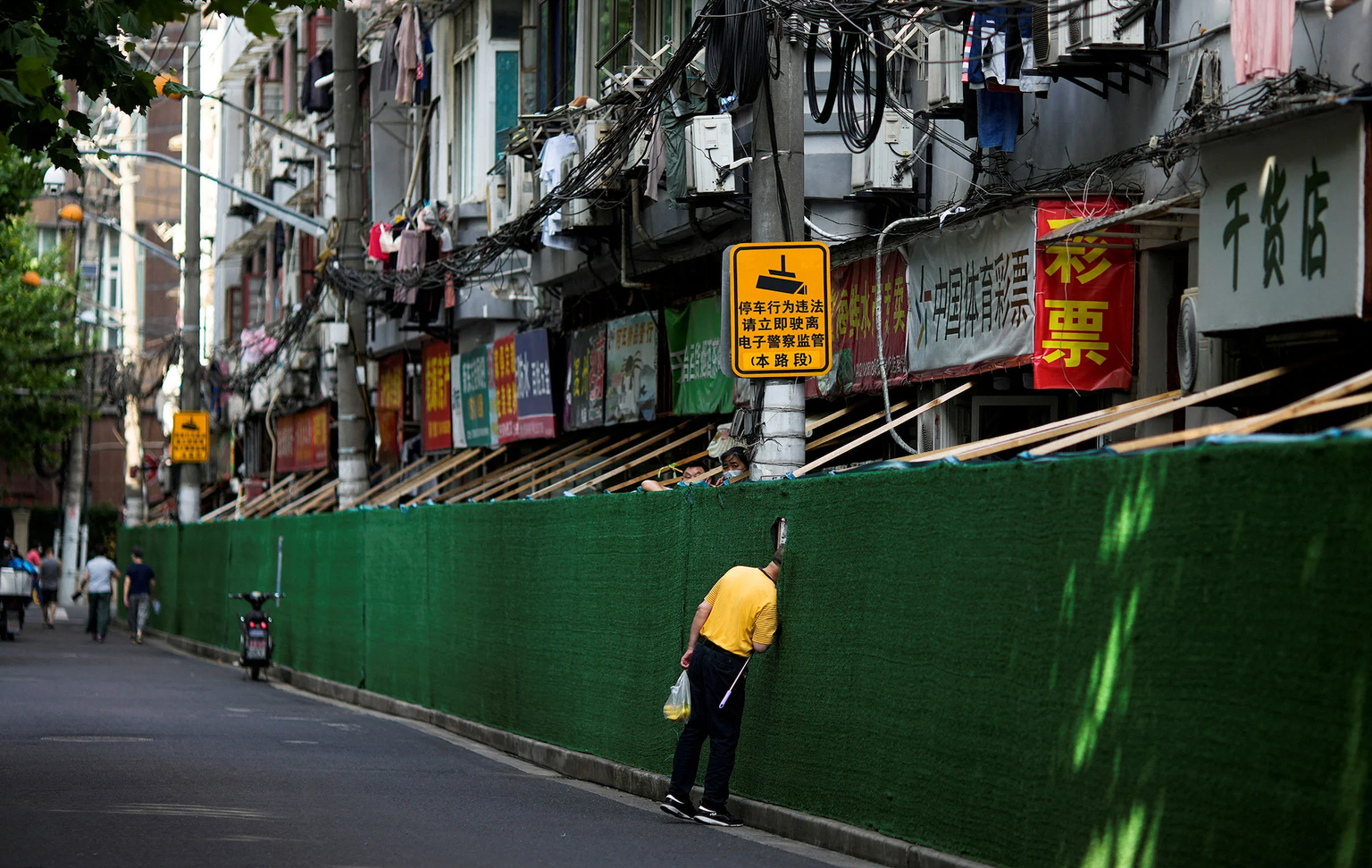 Un homme regarde à travers une ouverture, dans une zone résidentielle durant la politique zéro Covid à Shanghai, Chine, le 7 juin.