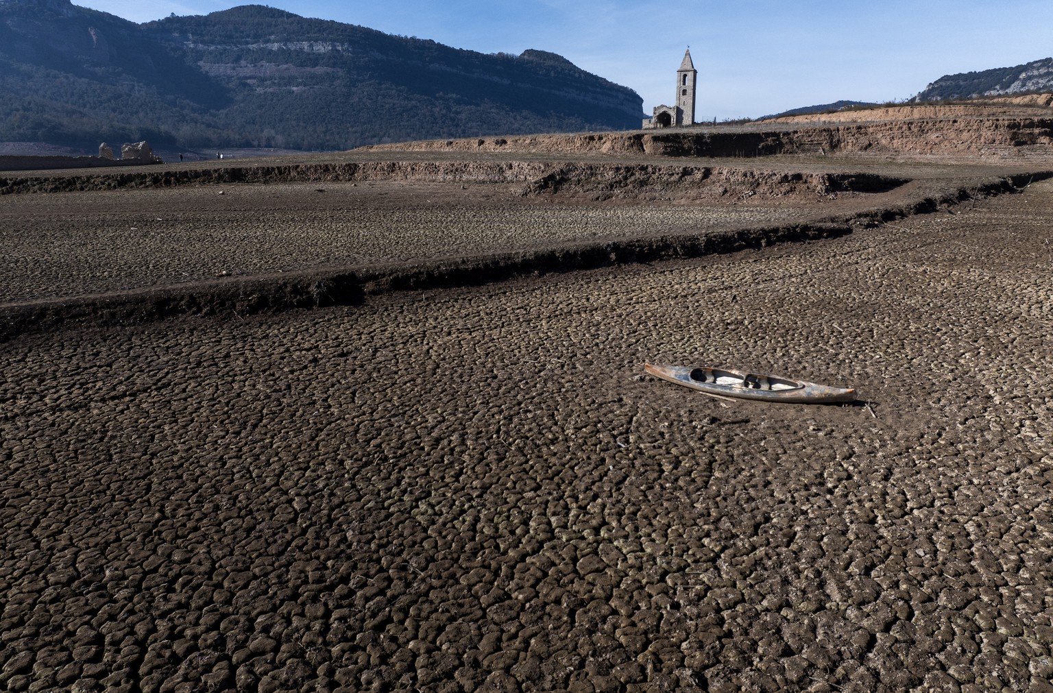 An abandoned canoe lies on the cracked ground at the Sau reservoir, which is only at 5 percent of its capacity, in Vilanova de Sau, about 100 km (62 miles) north of Barcelona, Spain, Friday, Jan. 26,  ...