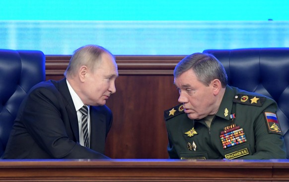 epa09652542 Russian President Vladimir Putin (L) listens to Chief of the Russian Armed Forces General Staff, First Deputy Defense Minister, Army General Valery Gerasimov (R) during an expanded meeting ...