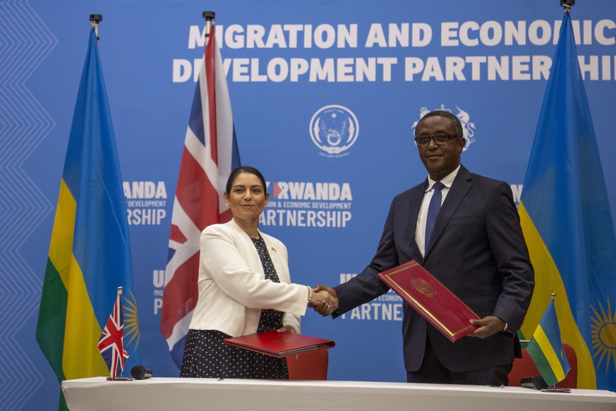 Britain&#039;s Home Secretary Priti Patel, left, shakes hands with Rwanda&#039;s Minister of Foreign Affairs Vincent Biruta, right, after signing what the two countries called an &quot;economic develo ...