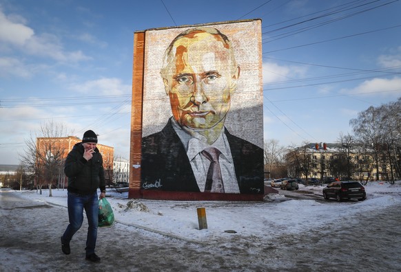 epa10401661 A man walks past a large mural depicting Russian President Vladimir Putin, on the side of a five-story residential building in Kashira, Moscow region, Russia, 12 January 2023. The years-ol ...