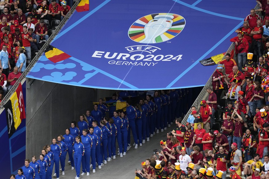 Volunteers get ready to enter the pitch for the open ceremony of the Group E match between Belgium and Slovakia at the Euro 2024 soccer tournament in Frankfurt, Germany, Monday, June 17, 2024. (AP Pho ...