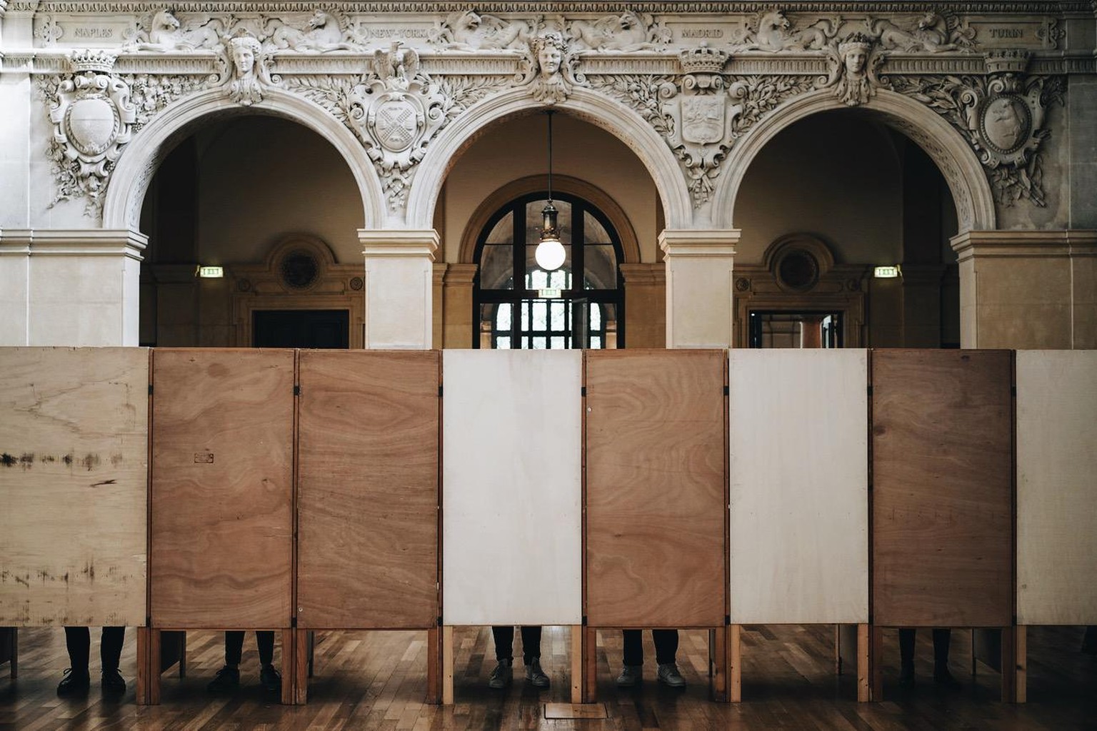 Voters stand in voting booths at a polling station in Lyon, central France, Sunday, April 24, 2022. France began voting in a presidential runoff election with repercussions for Europe&#039;s future, w ...