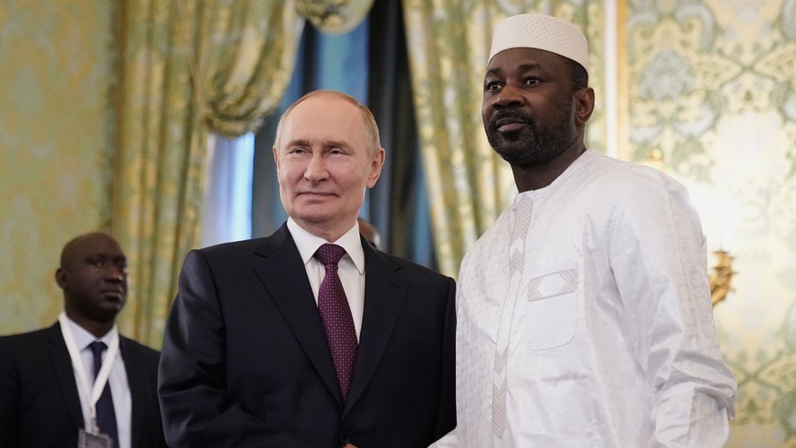 epa12192792 Russian President Vladimir Putin (C) shakes hands with Interim President of the Republic of Mali Assimi Goita (R) during their meeting at the Kremlin in Moscow, Russia, 23 June 2025. EPA/P ...