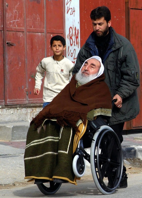 Picture dated 16 January 2004 shows spiritual leader of the Palestinian militant group Hamas Sheikh Ahmed Yassin and his bodyguard leaving a mosque in Gaza City. (KEYSTONE/EPA/Mohammed Saber)