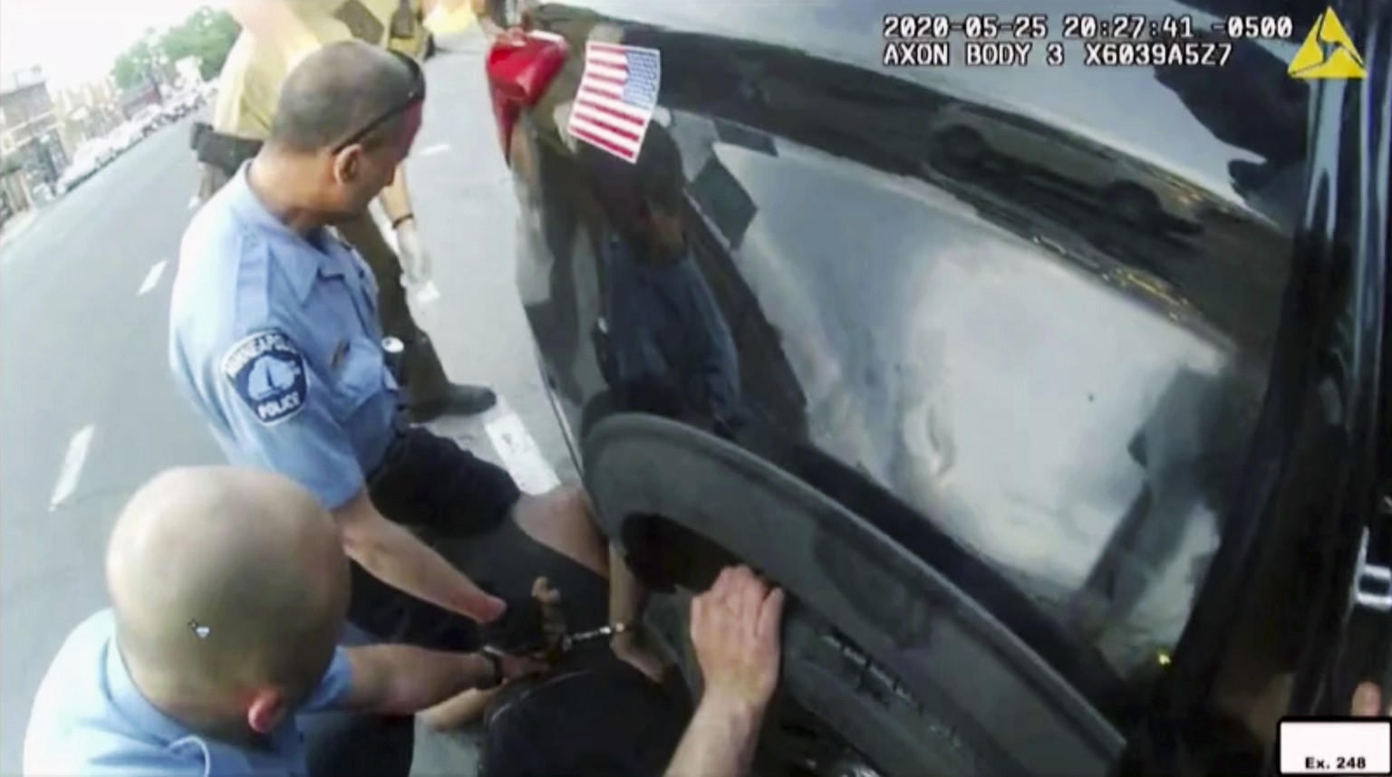 FILE - In this image from police body camera video shown as evidence in court, paramedics arrive as Minneapolis police officers, including Derick Chauvin, second from left, and J. Alexander Kueng rest ...