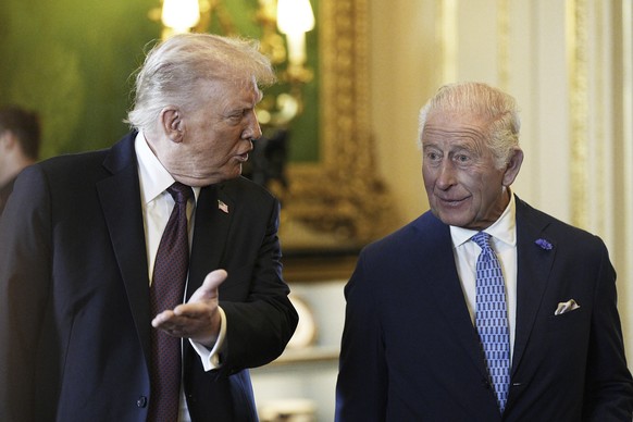 President Donald Trump, left, and Britain&#039;s King Charles III view items on display during a visit to the Royal Collection exhibition, in the Green Drawing Room at Windsor Castle, in Windsor, Engl ...